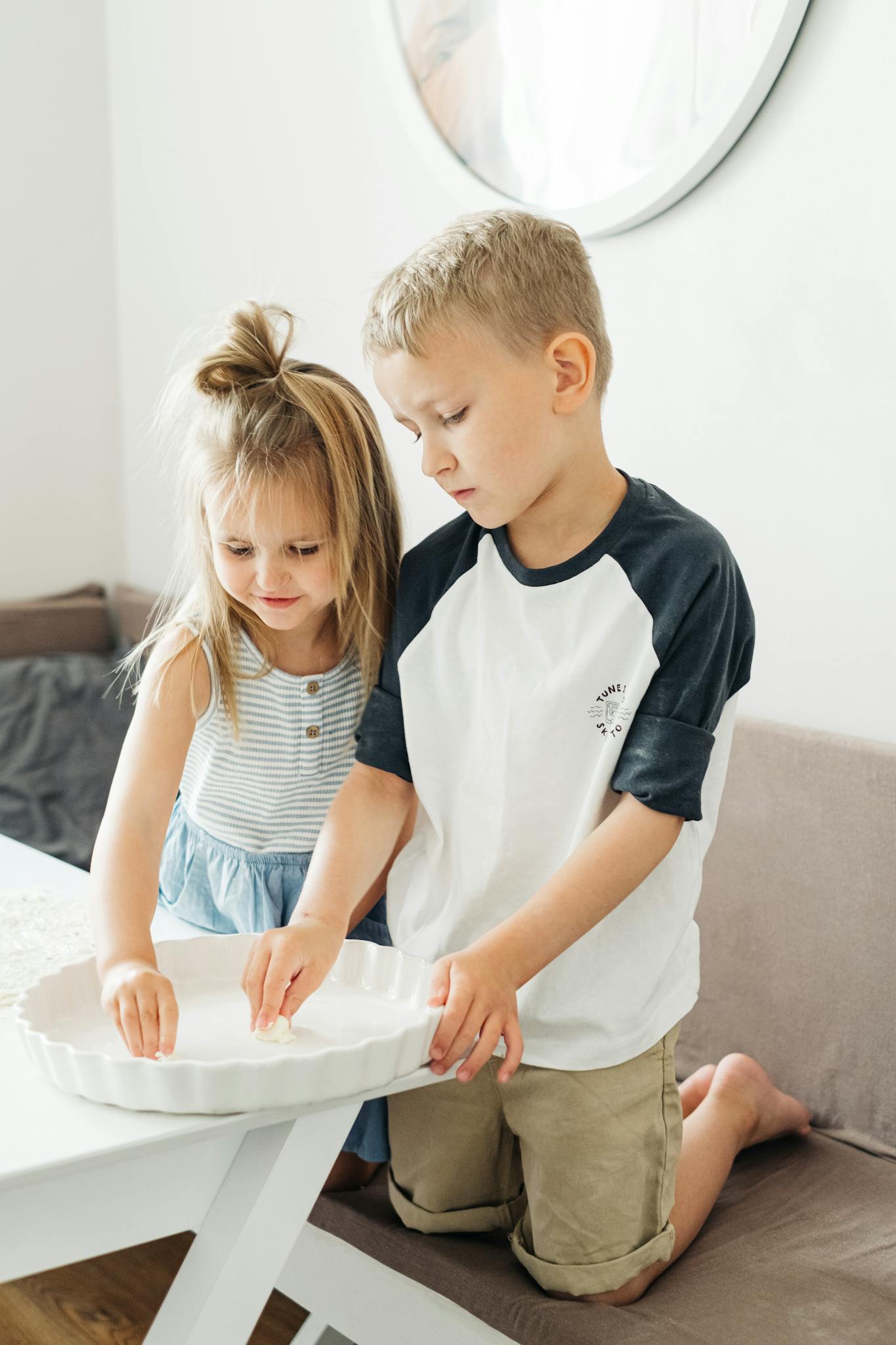 Cute siblings enjoying quality time baking in a bright kitchen, full of joy and connection.