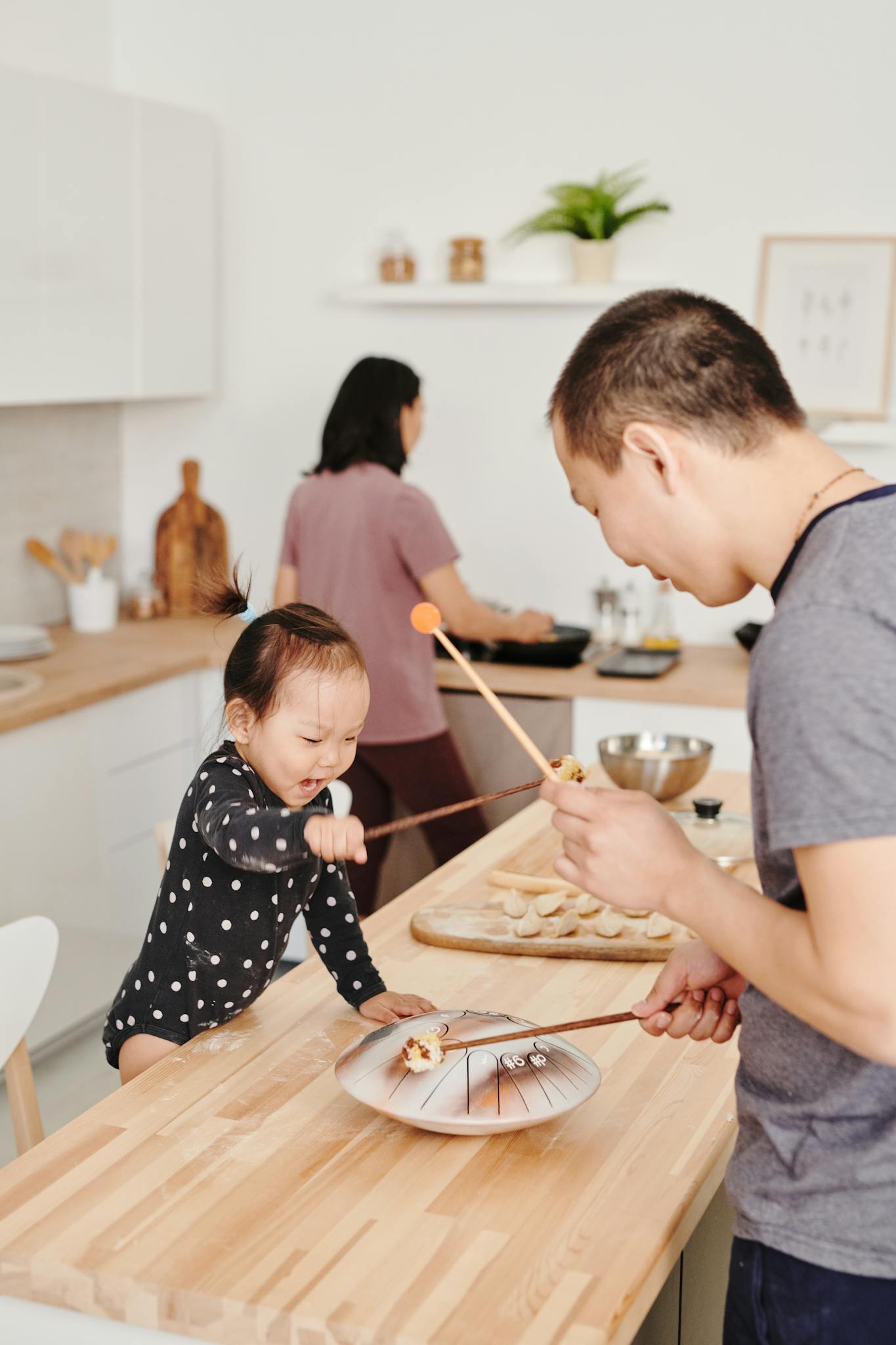 Father and daughter enjoy playful bonding time in a modern kitchen setting.